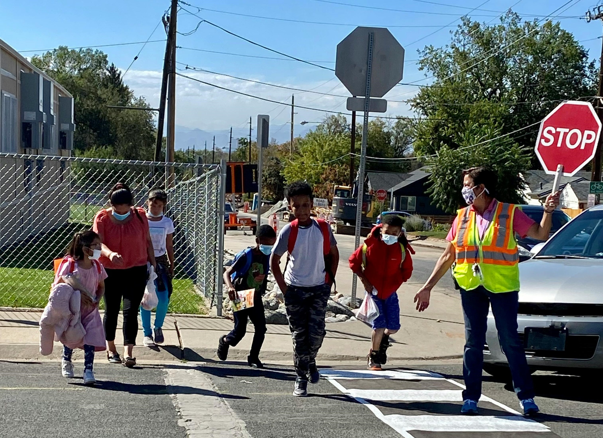 kids crossing street with crossing guard